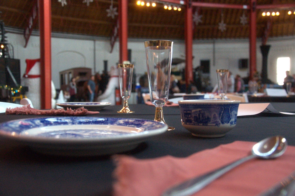 This is an image of a table set with nice blue and white china, with black and red linens.